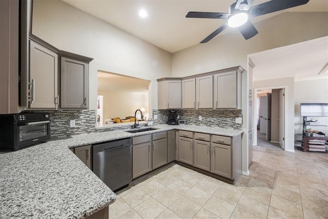 kitchen with dishwasher, sink, gray cabinetry, backsplash, and light stone countertops