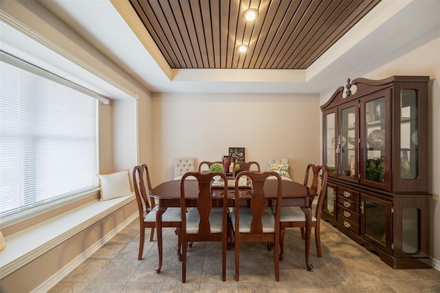 dining area featuring wood ceiling and a tray ceiling