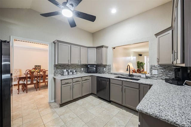 kitchen with sink, gray cabinets, refrigerator, light stone countertops, and stainless steel dishwasher