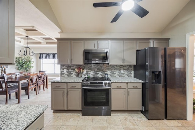 kitchen with backsplash, lofted ceiling with beams, light stone countertops, and appliances with stainless steel finishes