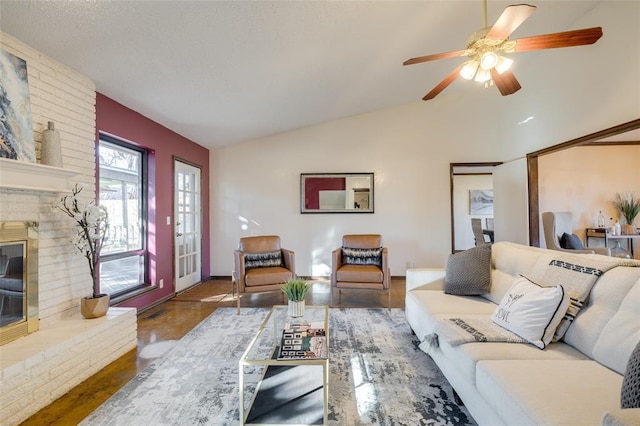 living room featuring ceiling fan, vaulted ceiling, and a brick fireplace