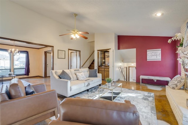 living room with ceiling fan with notable chandelier and high vaulted ceiling