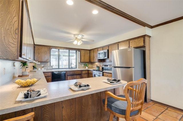 kitchen featuring crown molding, stainless steel appliances, a kitchen breakfast bar, and kitchen peninsula