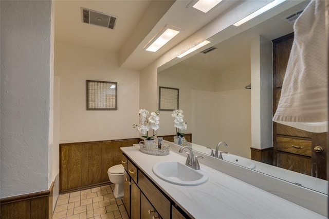 bathroom featuring vanity, walk in shower, and toilet