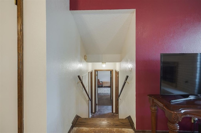 stairs with a textured ceiling