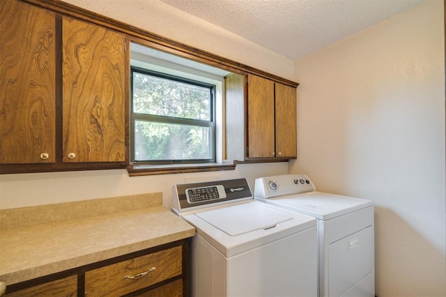 laundry room with separate washer and dryer, cabinets, and a textured ceiling