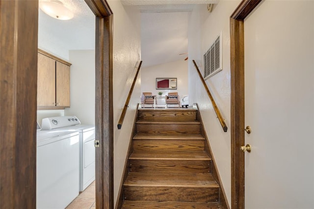 stairs with tile patterned floors and washing machine and clothes dryer