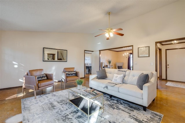 living room with concrete flooring, ceiling fan with notable chandelier, and high vaulted ceiling