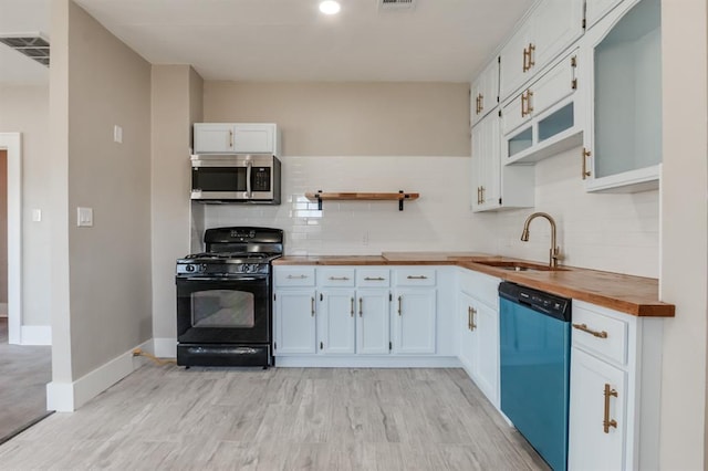 kitchen featuring white cabinets, appliances with stainless steel finishes, wooden counters, and sink