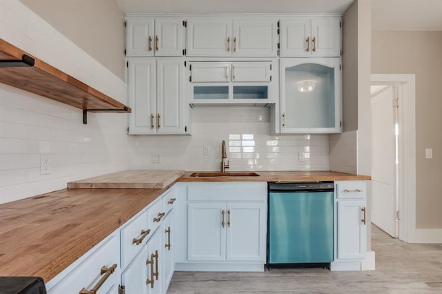 kitchen with wooden counters, white cabinetry, dishwasher, and sink