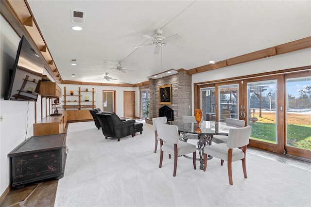 carpeted dining room with french doors, a fireplace, plenty of natural light, and vaulted ceiling