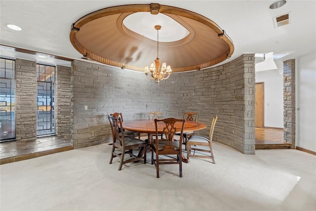 dining room featuring a raised ceiling and a chandelier