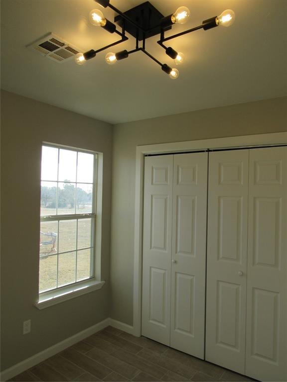 unfurnished bedroom featuring a closet and a notable chandelier