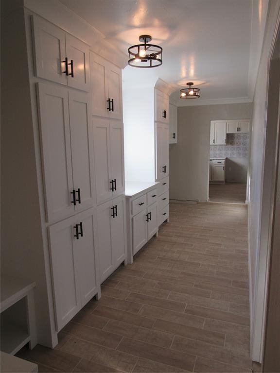 corridor with hardwood / wood-style floors and a notable chandelier