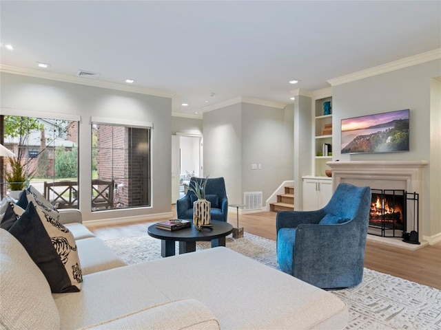 living room with light hardwood / wood-style flooring and ornamental molding