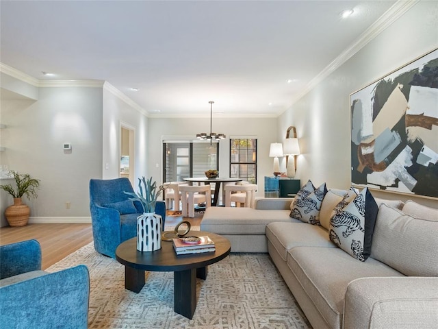 living room with crown molding, light hardwood / wood-style floors, and a notable chandelier