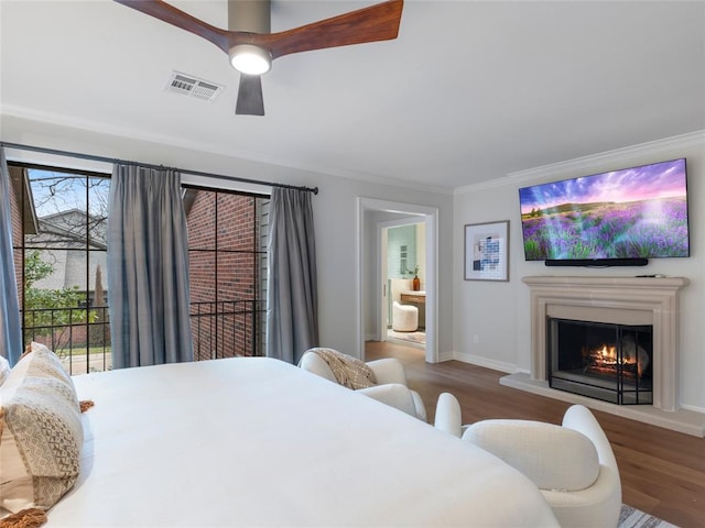 bedroom featuring hardwood / wood-style floors, ceiling fan, ornamental molding, and multiple windows