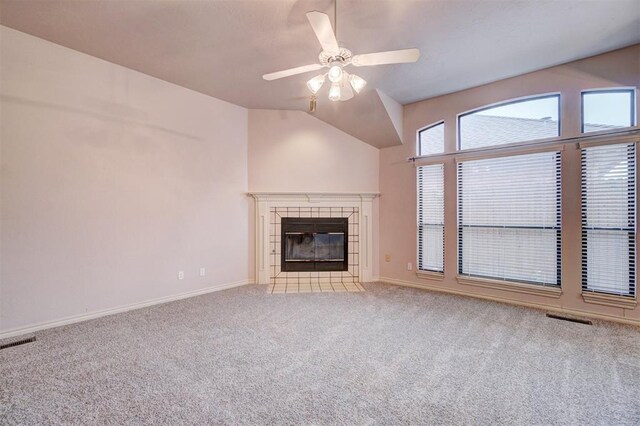 unfurnished living room with ceiling fan, light carpet, a tile fireplace, and vaulted ceiling