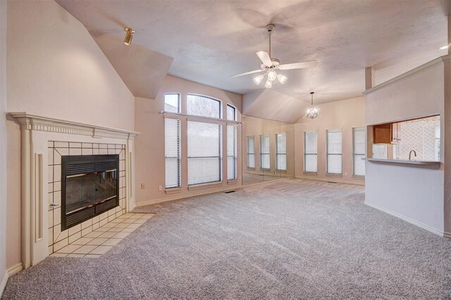 unfurnished living room with a fireplace, ceiling fan with notable chandelier, light colored carpet, and lofted ceiling