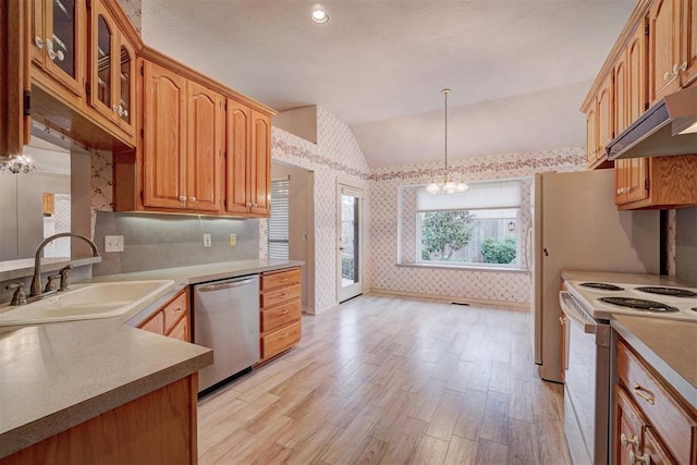 kitchen with vaulted ceiling, sink, an inviting chandelier, dishwasher, and hanging light fixtures