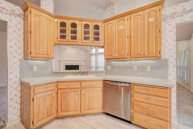 kitchen with backsplash, light brown cabinetry, dishwasher, and sink