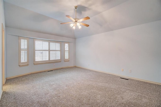 carpeted spare room with vaulted ceiling and ceiling fan