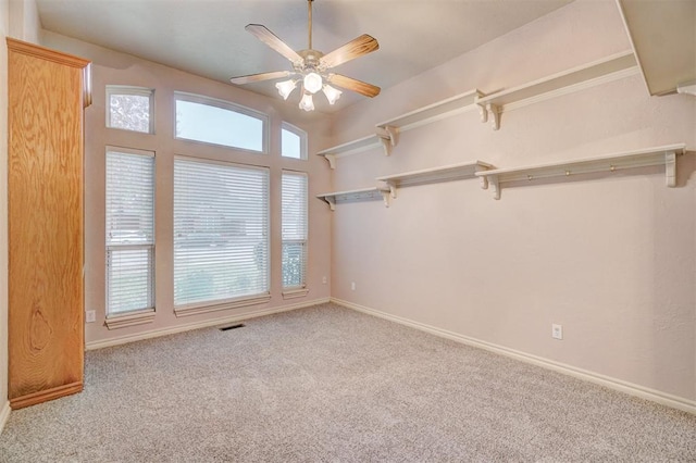 carpeted spare room featuring ceiling fan