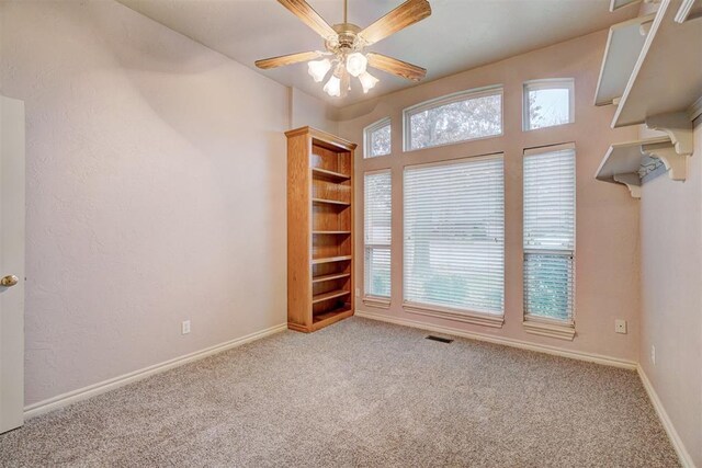 unfurnished room with carpet, a wealth of natural light, and ceiling fan