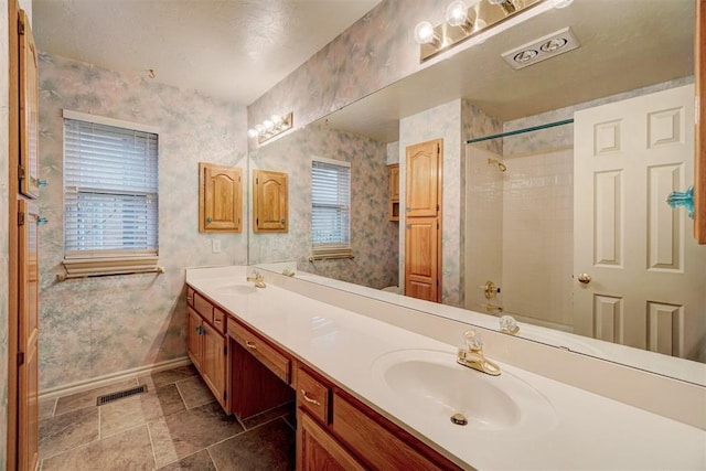 bathroom with vanity, tub / shower combination, and a textured ceiling