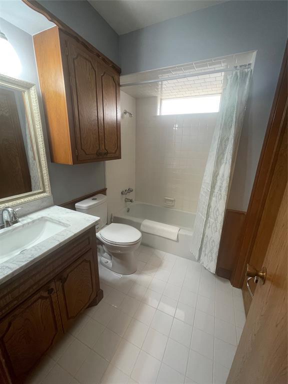 full bathroom with shower / bath combo with shower curtain, vanity, and toilet