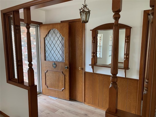 entrance foyer featuring light wood-type flooring, an inviting chandelier, and a healthy amount of sunlight