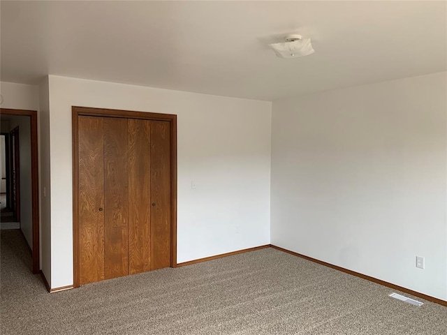 unfurnished bedroom featuring carpet and a closet