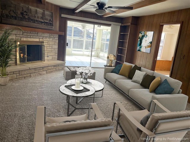 carpeted living room with ceiling fan, a fireplace, and wooden walls