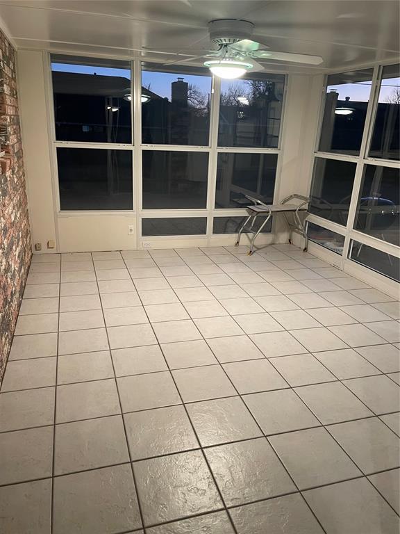 unfurnished sunroom featuring ceiling fan