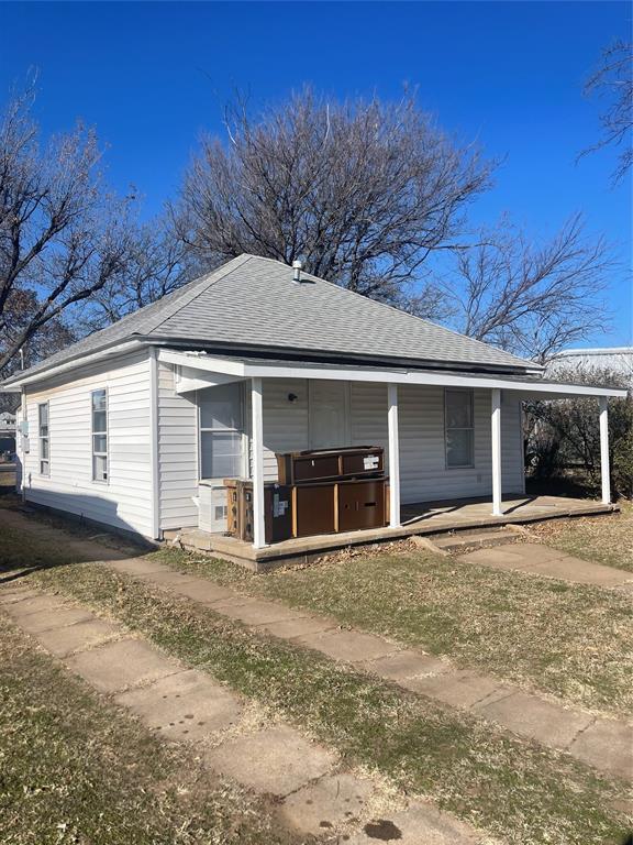 view of home's exterior with covered porch and a hot tub