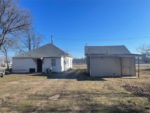 rear view of house with a lawn and central AC unit