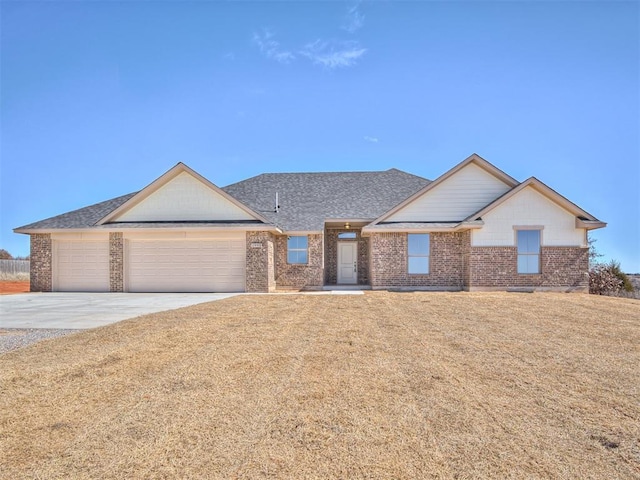 view of front facade featuring a garage, brick siding, a shingled roof, driveway, and a front lawn