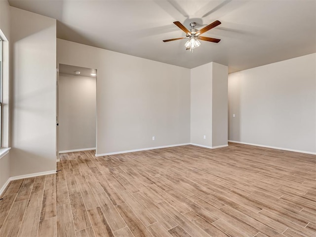 spare room with light wood-style floors, baseboards, and a ceiling fan