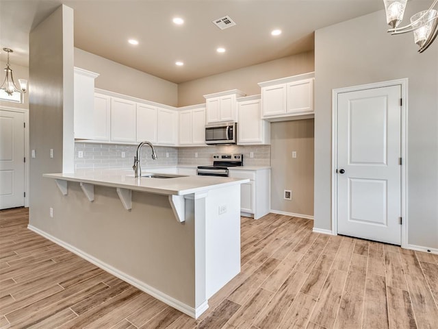 kitchen featuring a sink, visible vents, white cabinets, light countertops, and appliances with stainless steel finishes