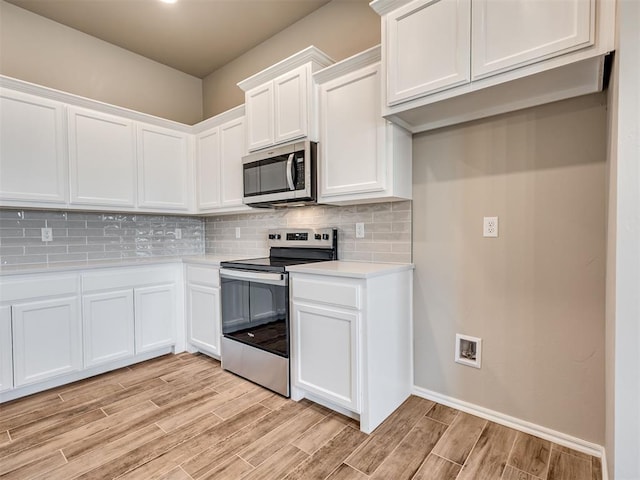 kitchen featuring white cabinetry, wood tiled floor, appliances with stainless steel finishes, and light countertops