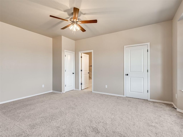 unfurnished bedroom featuring light carpet, ceiling fan, ensuite bath, and baseboards