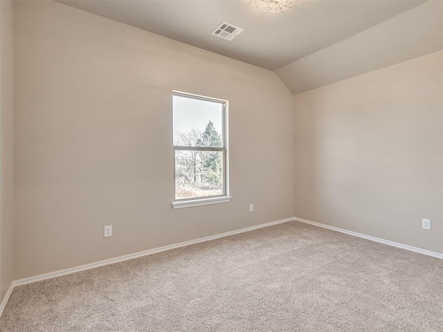 spare room with carpet, visible vents, vaulted ceiling, and baseboards