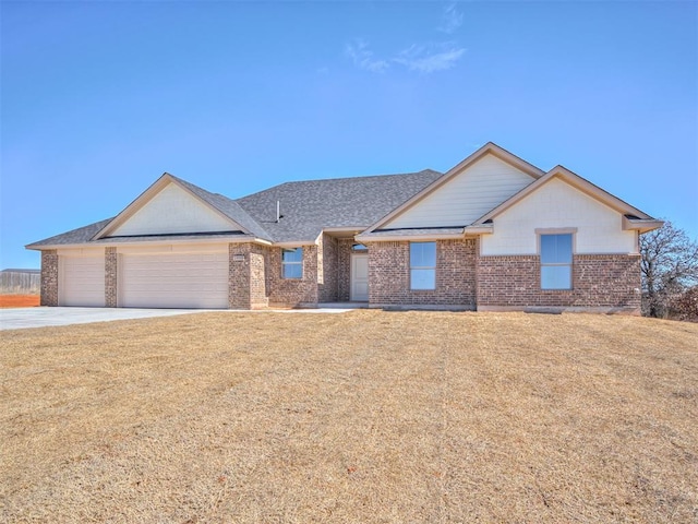 ranch-style home with brick siding, a shingled roof, concrete driveway, an attached garage, and a front yard