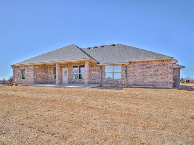 1995 Classic Run, Blanchard, OK 73010 - rear view of property featuring a shingled roof, brick siding, central AC, a patio area, and a lawn