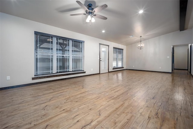 interior space with ceiling fan with notable chandelier, vaulted ceiling with beams, and light hardwood / wood-style floors