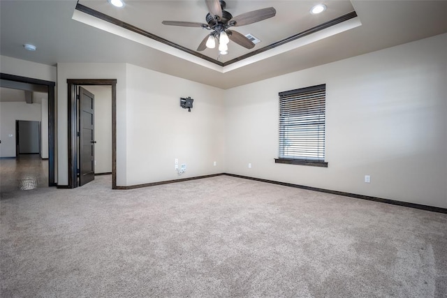 unfurnished room with carpet floors, a tray ceiling, ceiling fan, and ornamental molding