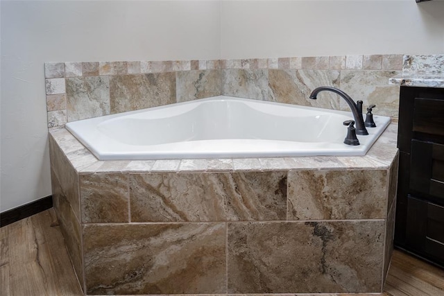 bathroom featuring vanity and a relaxing tiled tub