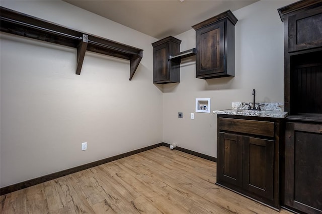 laundry area with electric dryer hookup, cabinets, bar area, hookup for a washing machine, and light hardwood / wood-style floors