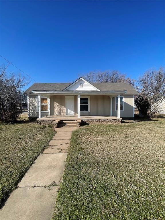 ranch-style home with covered porch and a front lawn