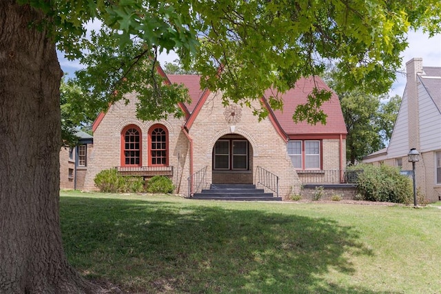 english style home featuring a front yard